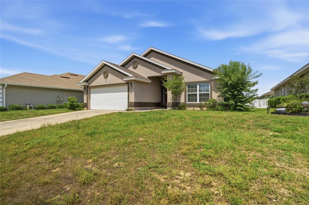 A single-story suburban house with a two-car garage and a grassy front yard — 3 DIAMOND COVE COURT, OCALA, FL