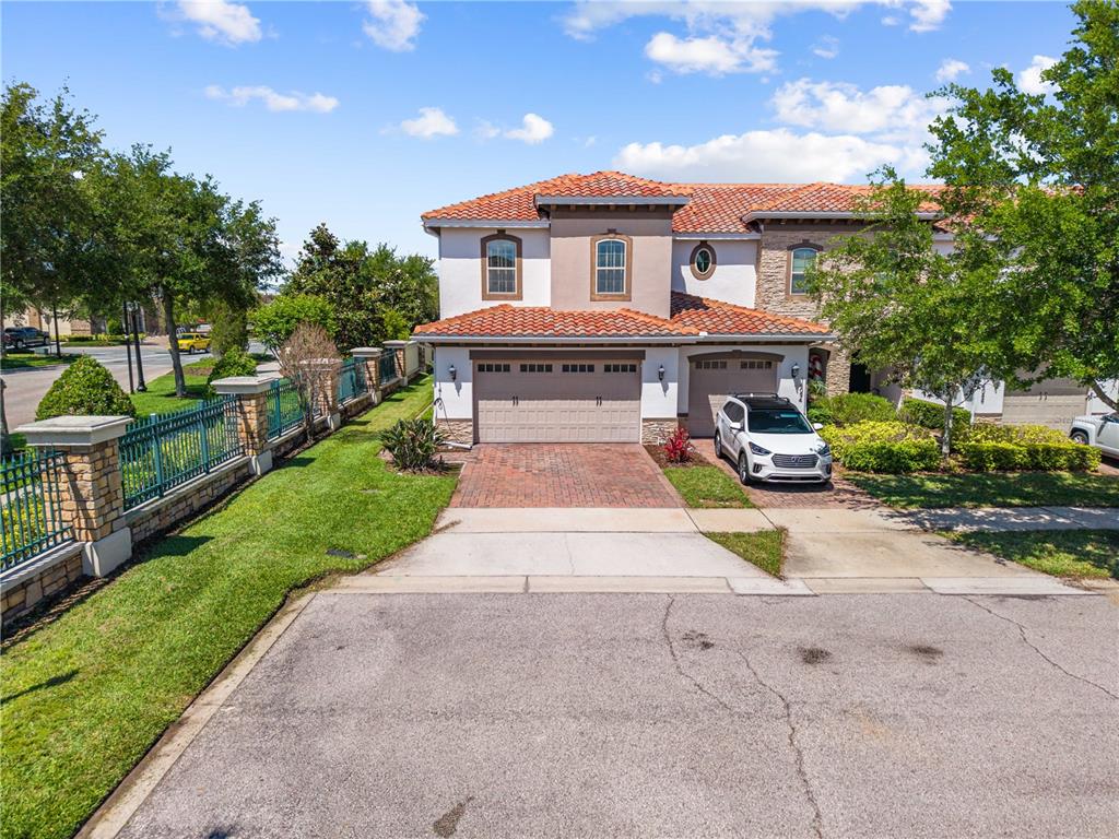An exterior view of a two-story house with a tile roof and a brick driveway — 14100 TARVIN STREET, ORLANDO, FL