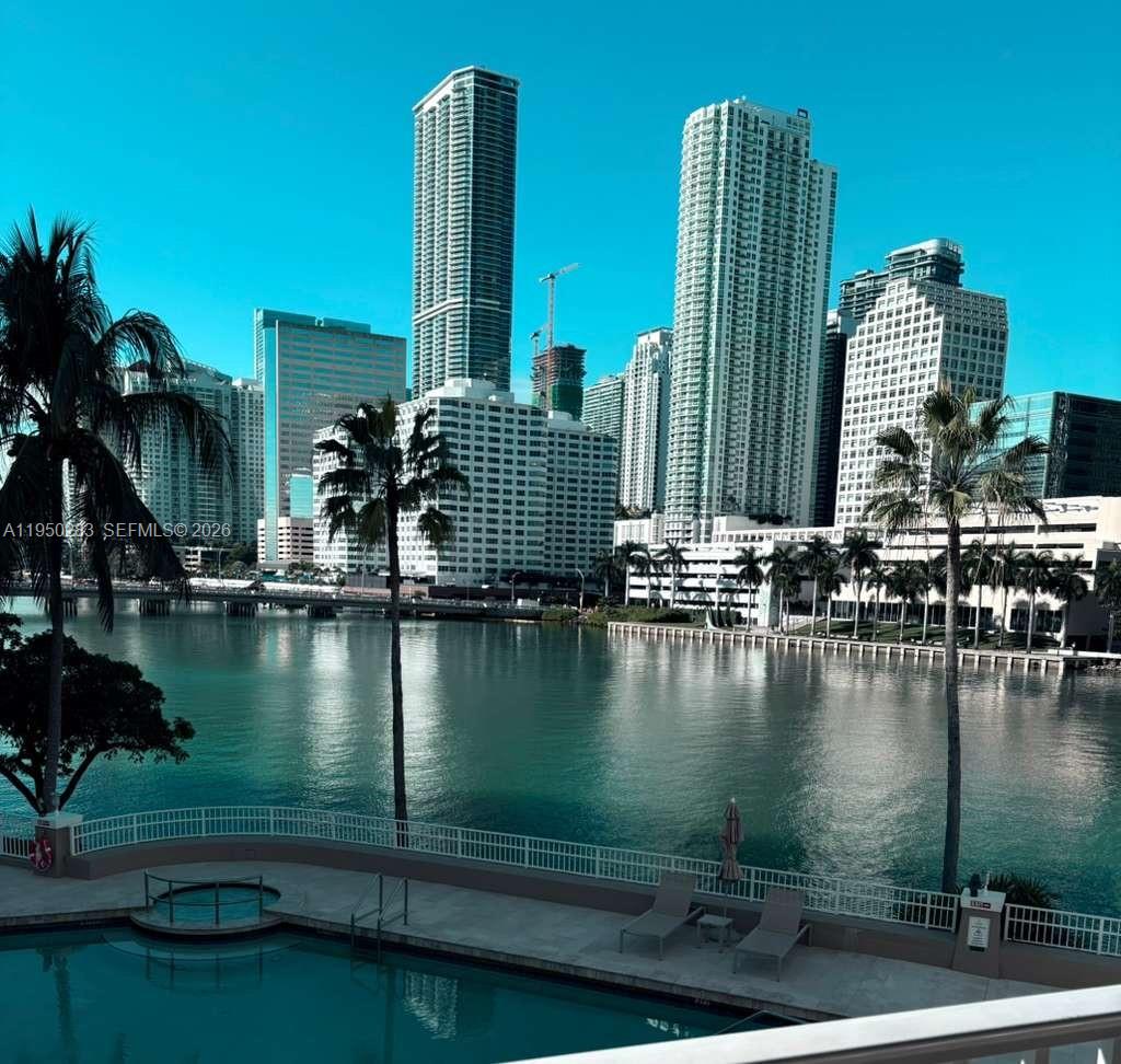A swimming pool overlooks a body of water with a city skyline in the background — 701 Brickell Key Blvd # 1105, Miami FL 33131, MIAMI, FL