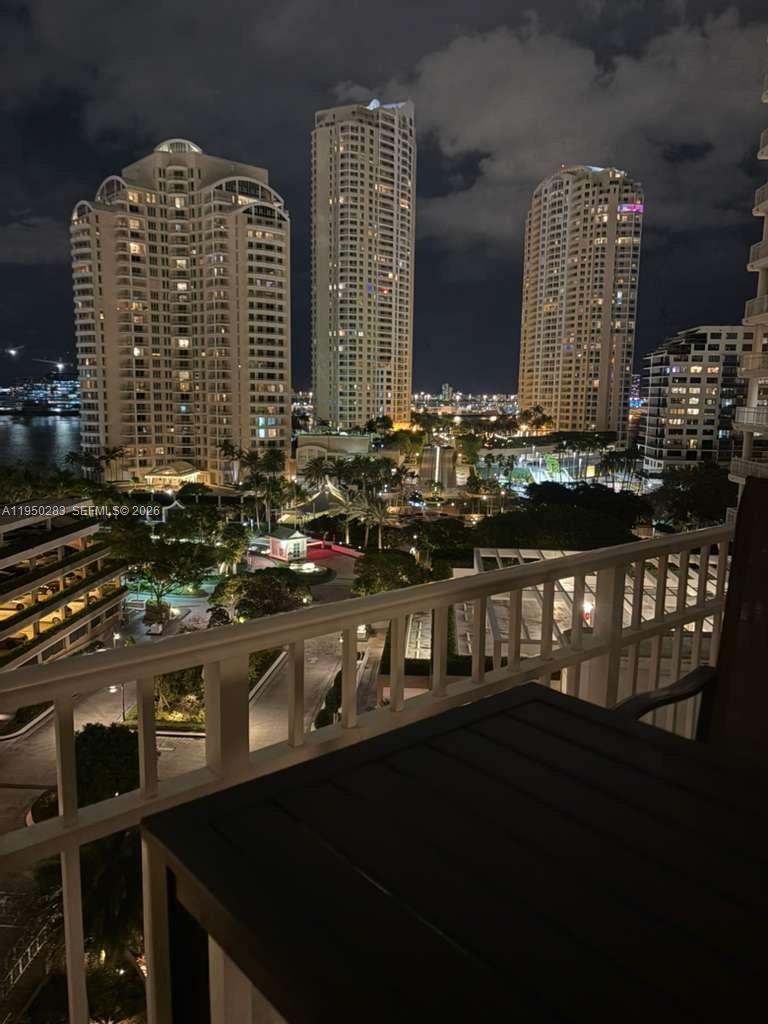 A night view from a balcony overlooking a park and several high-rise apartment buildings — 701 Brickell Key Blvd # 1105, Miami FL 33131, MIAMI, FL