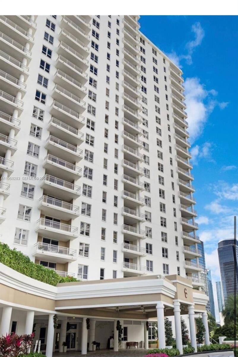 A low-angle exterior view of a tall, white residential high-rise building with many balconies — 701 Brickell Key Blvd # 1105, Miami FL 33131, MIAMI, FL