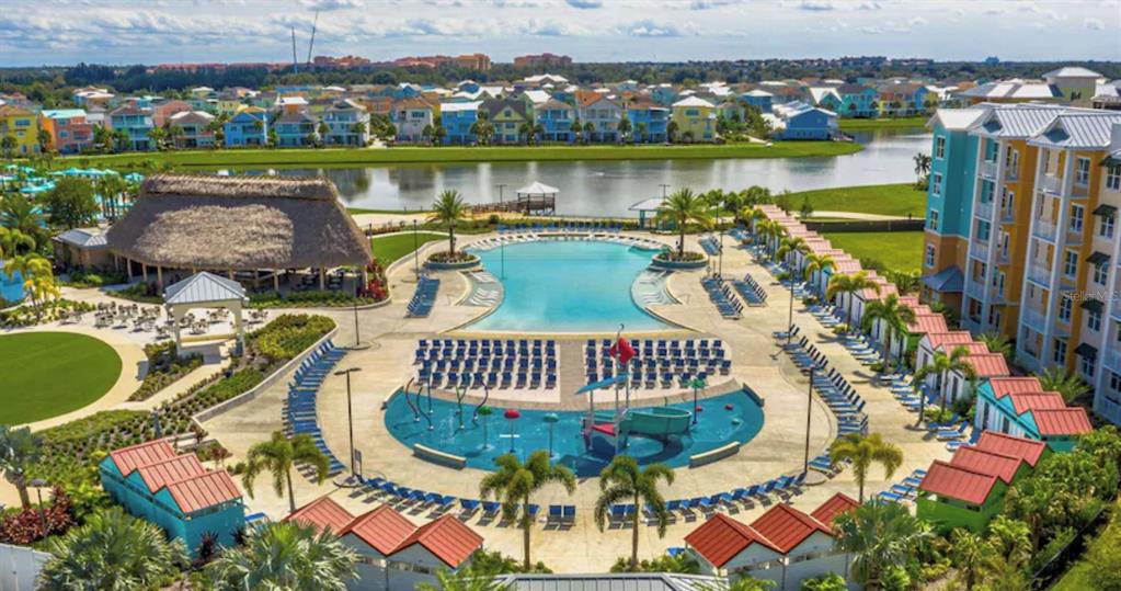 An aerial view of a resort pool area with a splash pad and surrounding cabanas — 3151 SUNSET WALK DRIVE UNIT 411, KISSIMMEE, FL