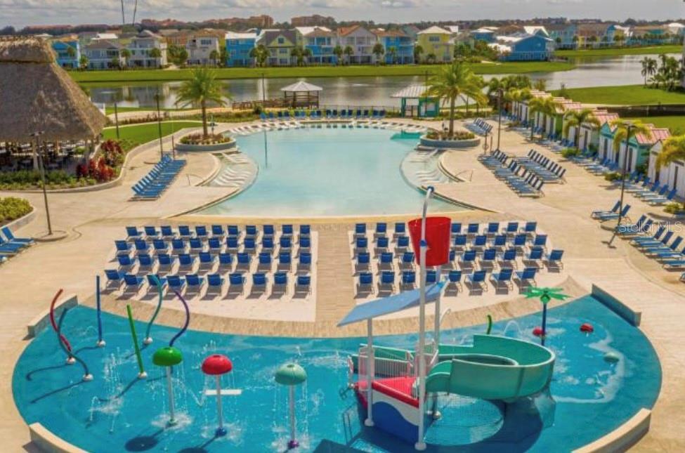 An aerial view of a resort-style swimming pool and a colorful children's splash pad area — 3151 SUNSET WALK DRIVE UNIT 411, KISSIMMEE, FL