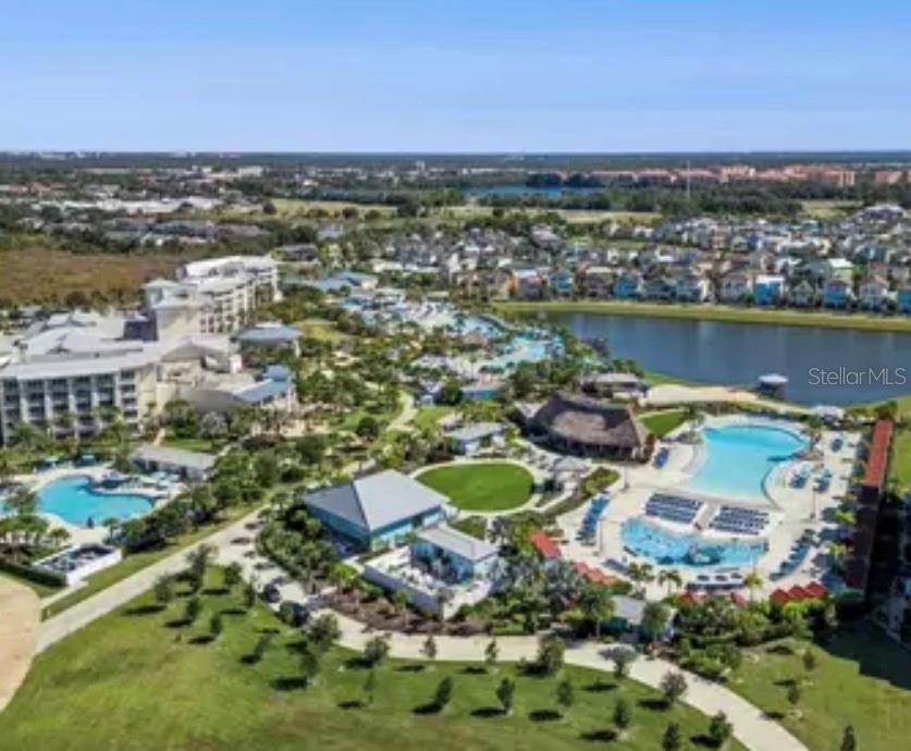 An aerial view of a resort complex featuring multiple swimming pools, buildings, and a lake — 3151 SUNSET WALK DRIVE UNIT 411, KISSIMMEE, FL