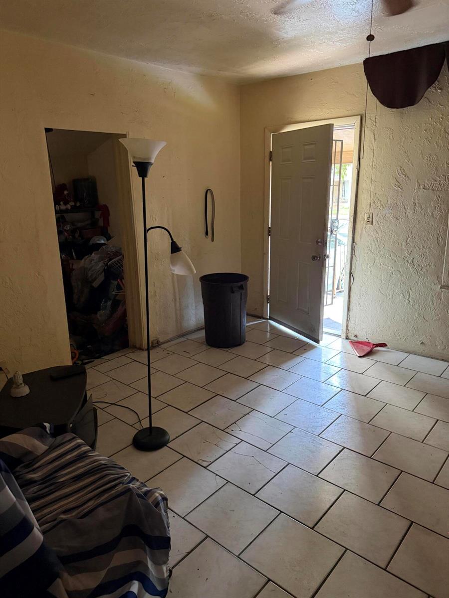 A room with white tile floors, a floor lamp, a trash can, and an open door — 1280 NW 51ST Street, Miami FL 33142, MIAMI, FL