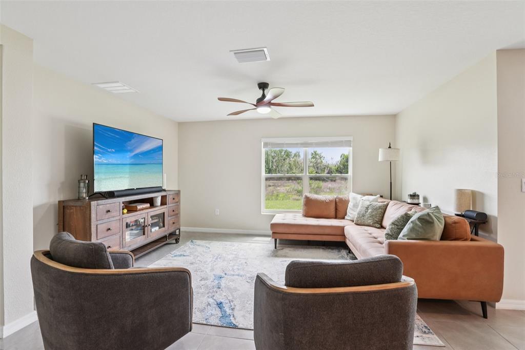 A living room features a sectional sofa, two armchairs, a television, and a ceiling fan — 1804 TAHITIAN SUNRISE DRIVE, PLANT CITY, FL