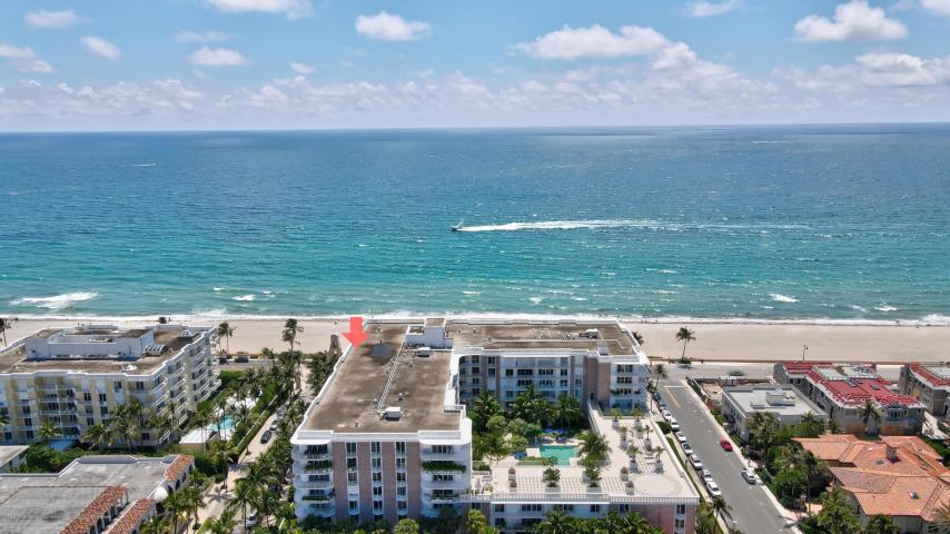 An aerial view of a multi-story beachfront condominium complex with a pool and parking lot — 100 Worth Avenue # 7, Palm Beach FL 33480, PALM BEACH, FL
