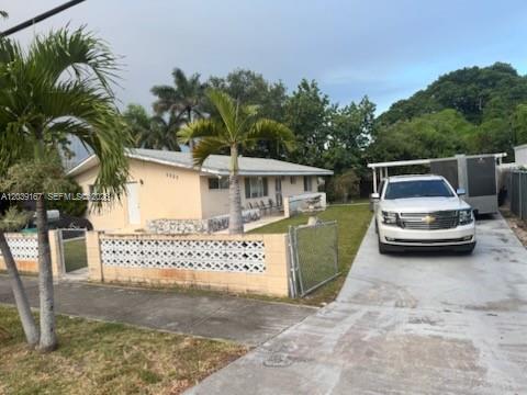 A single-story house with a white exterior, a concrete driveway, and a decorative block wall — 5955 NW 18th Ave, Miami FL 33142, MIAMI, FL