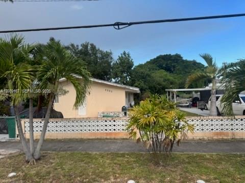 A single-story house with a light-colored exterior sits behind a decorative concrete block wall — 5955 NW 18th Ave, Miami FL 33142, MIAMI, FL