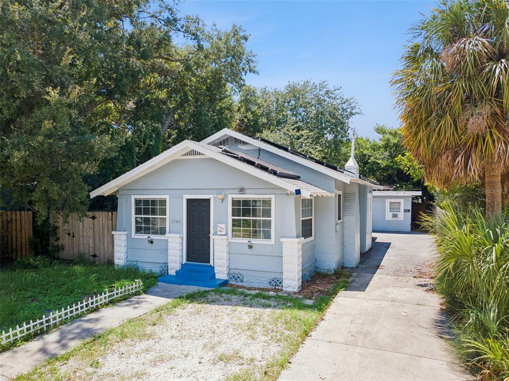 A light blue, single-story house with a front porch, white trim, and a concrete driveway — 1743 YALE STREET S, ST PETERSBURG, FL
