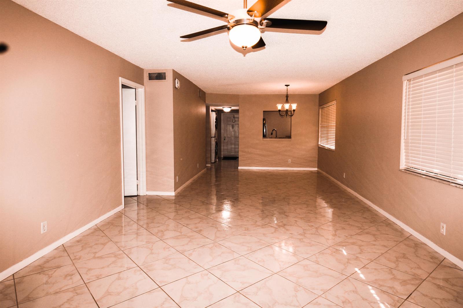 An empty room with beige walls, tile flooring, a ceiling fan, and a pass-through window — 2955 SW 22nd Avenue # 2080, Delray Beach FL 33445, DELRAY BEACH, FL