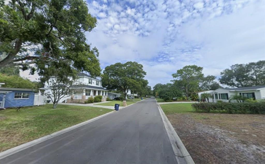 A street view showing houses, mature trees, and a paved road under a cloudy sky — 3626 S OMAR AVENUE, TAMPA, FL