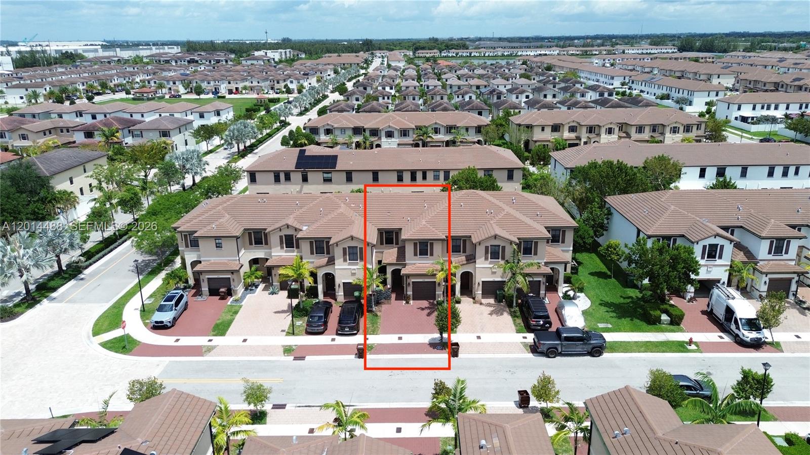 An aerial view shows a row of tan townhouses with red-tiled roofs and driveways — 3469 W 106th St, Hialeah FL 33018, HIALEAH, FL