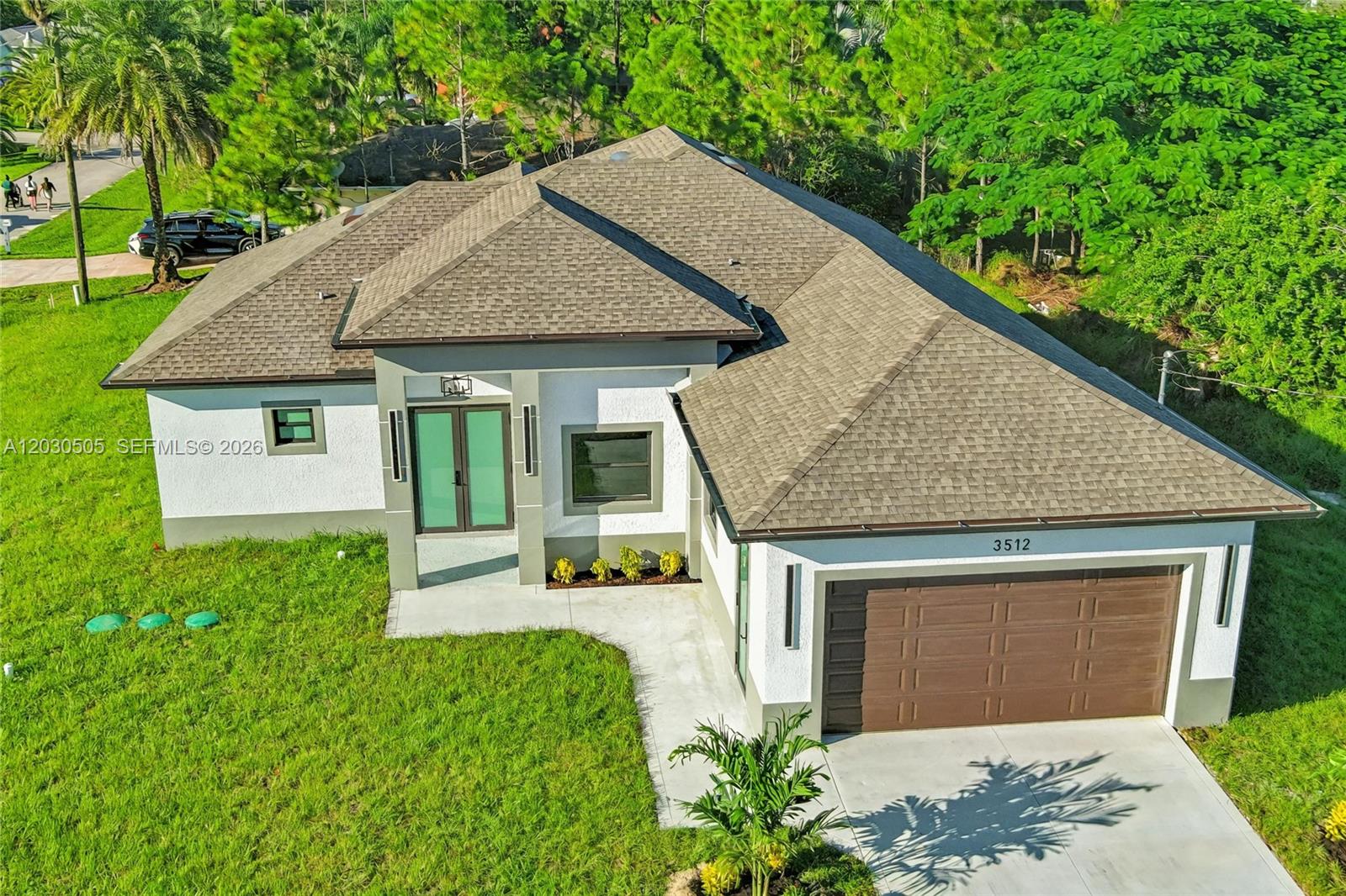 An aerial view shows the front exterior of a single-story house with a garage — 3512 9TH STREET W, Lehigh Acres FL 33971, LEHIGH ACRES, FL