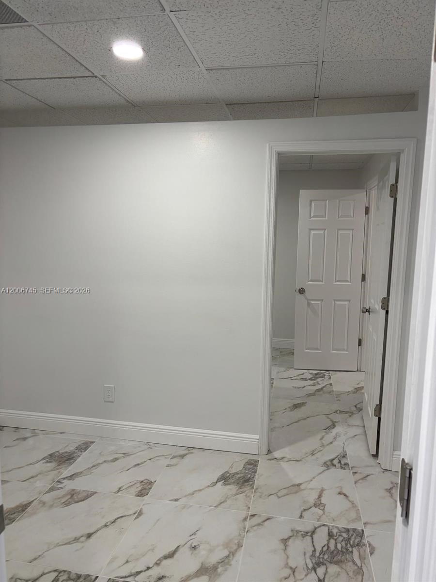 A room with white walls, a drop ceiling, and light-colored marble-patterned tile flooring — 5327 Commercial Way # B105, FL 34606, FL