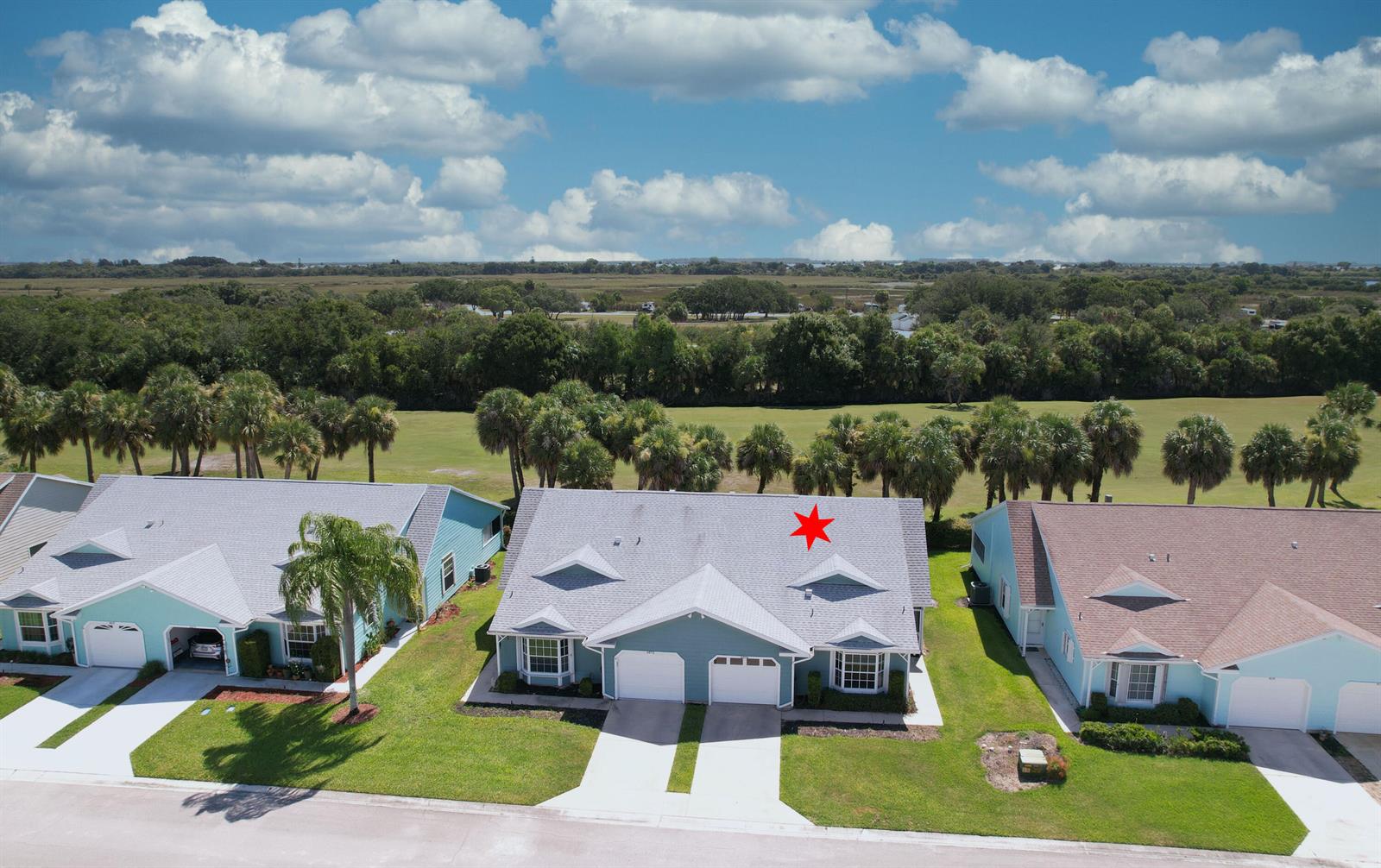 An aerial view shows a teal duplex house with a gray roof and two garages — 4074 Gator Trace Road, Fort Pierce FL 34982, FORT PIERCE, FL