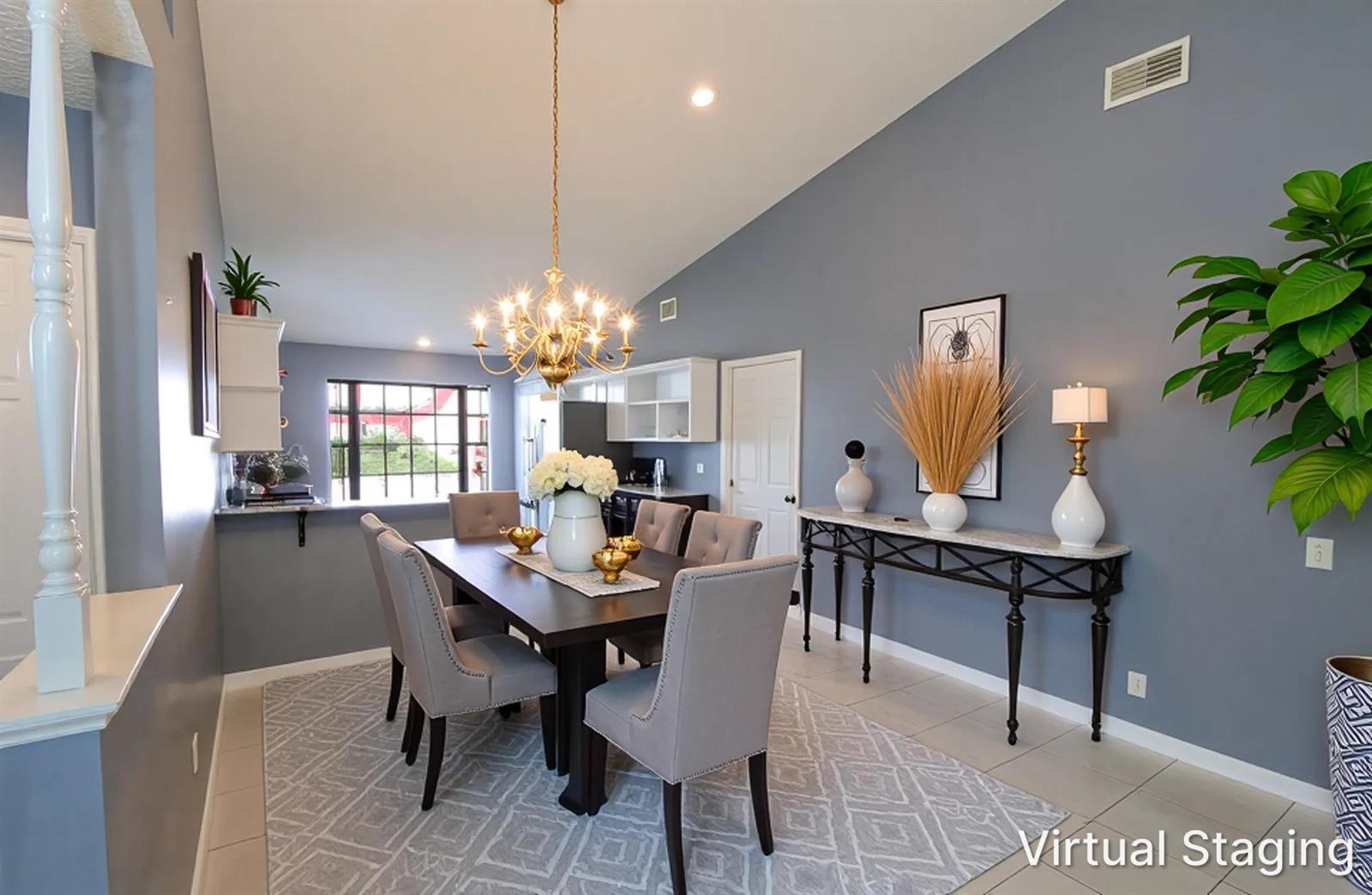 This dining room features a dark wood table, gray upholstered chairs, and a gold chandelier — 4074 Gator Trace Road, Fort Pierce FL 34982, FORT PIERCE, FL