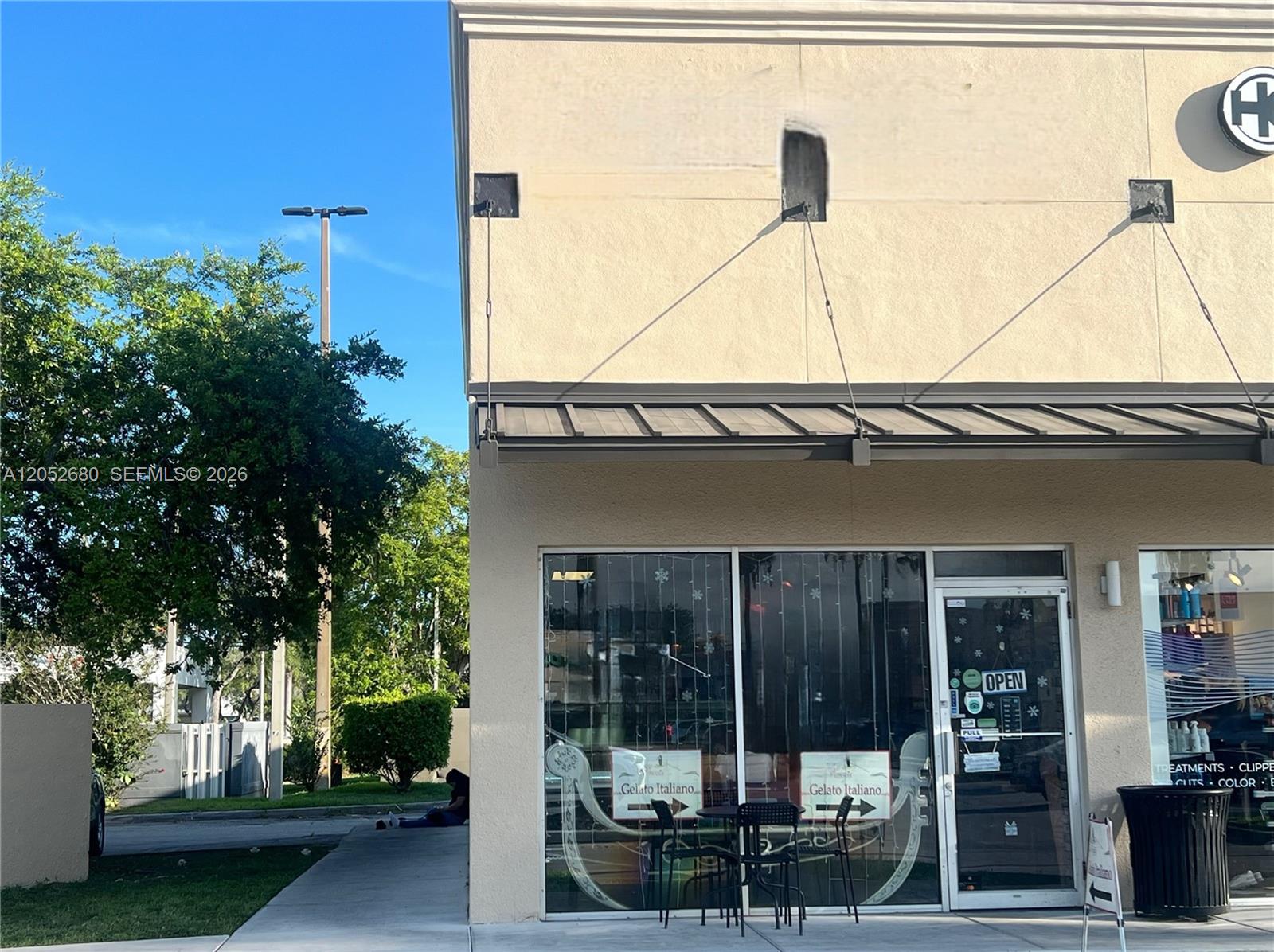 A storefront with a metal awning, glass windows, and a sign advertising gelato — KENDALL, FL