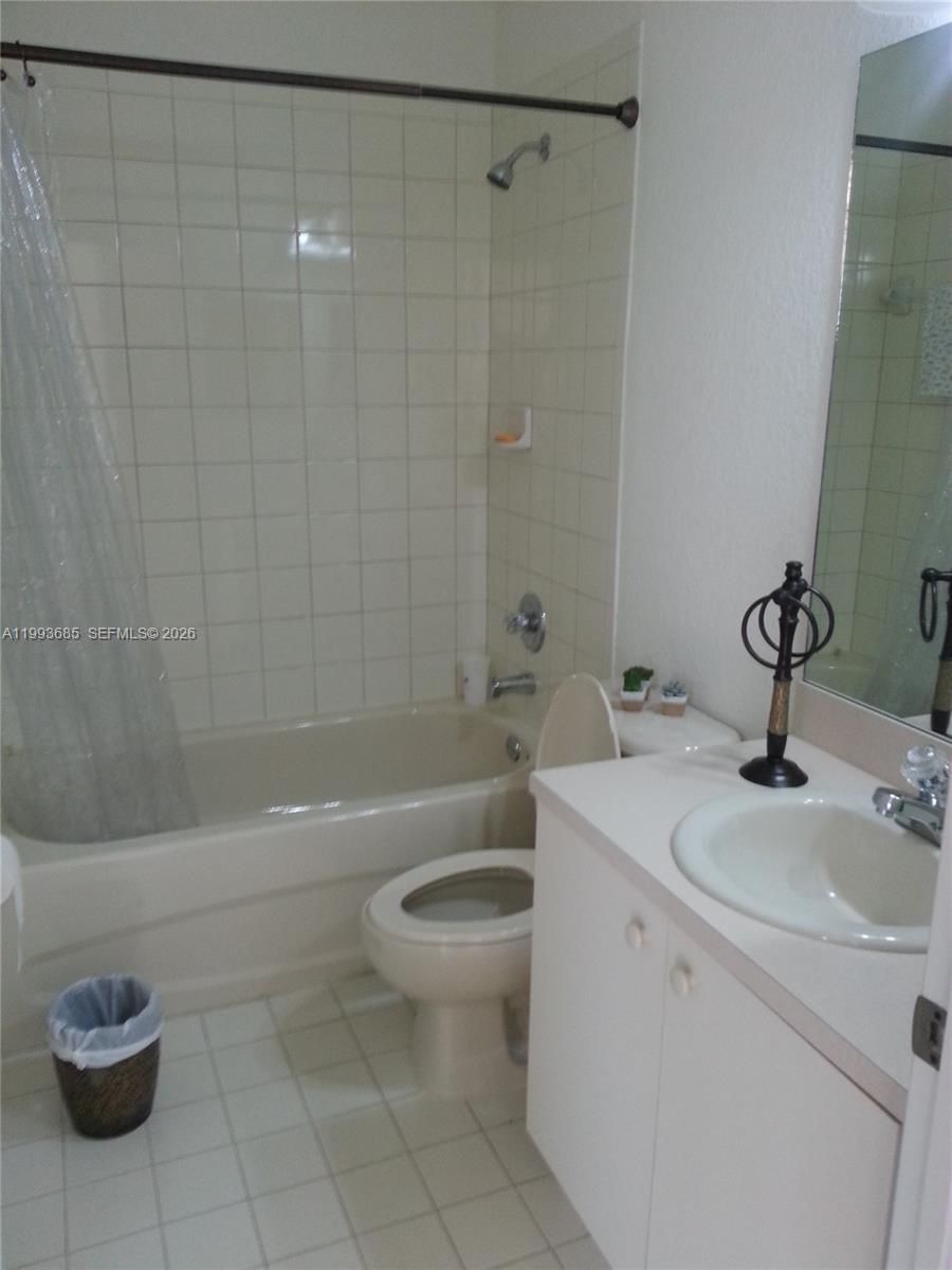 A bathroom features a white vanity, a toilet, and a bathtub with a shower curtain — 11050 NW 86th Ter, Doral FL 33178, DORAL, FL