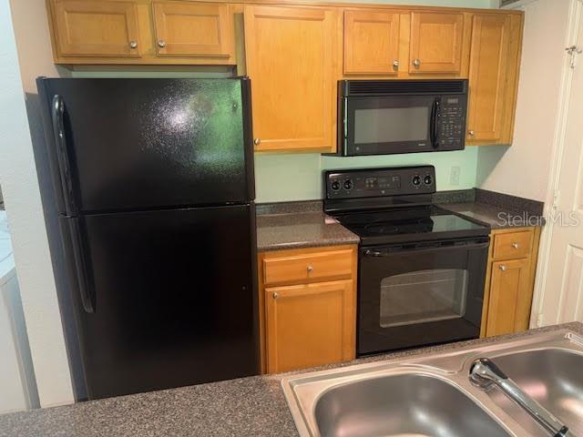 A kitchen features light wood cabinets, black appliances, and a double-basin stainless steel sink — 365 FORESTWAY CIRCLE UNIT 303, ALTAMONTE SPRINGS, FL
