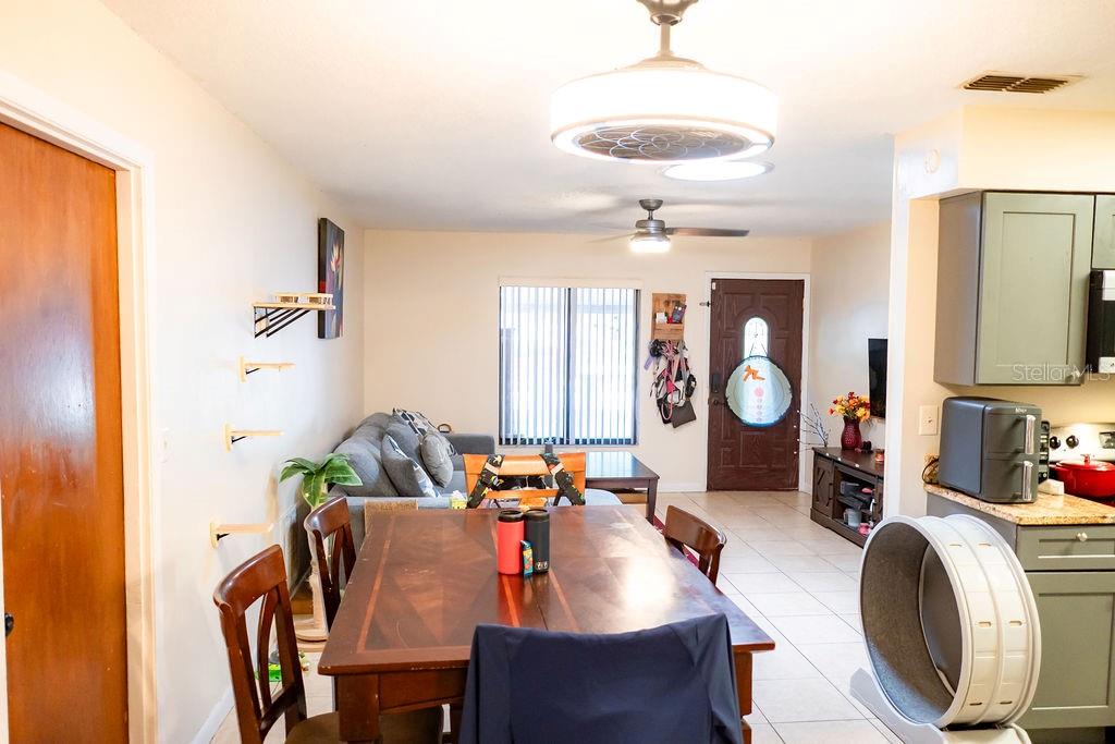 A dining area with a wooden table sits in front of a living room space — 8204 TRAMMELL TRAIL, TAMPA, FL