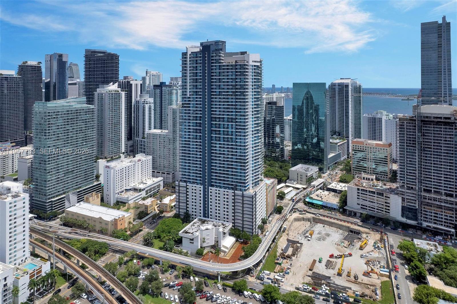 An aerial view of a dense city skyline featuring high-rise buildings and a train track — 60 SW 13th St # 3400, Miami FL 33130, MIAMI, FL