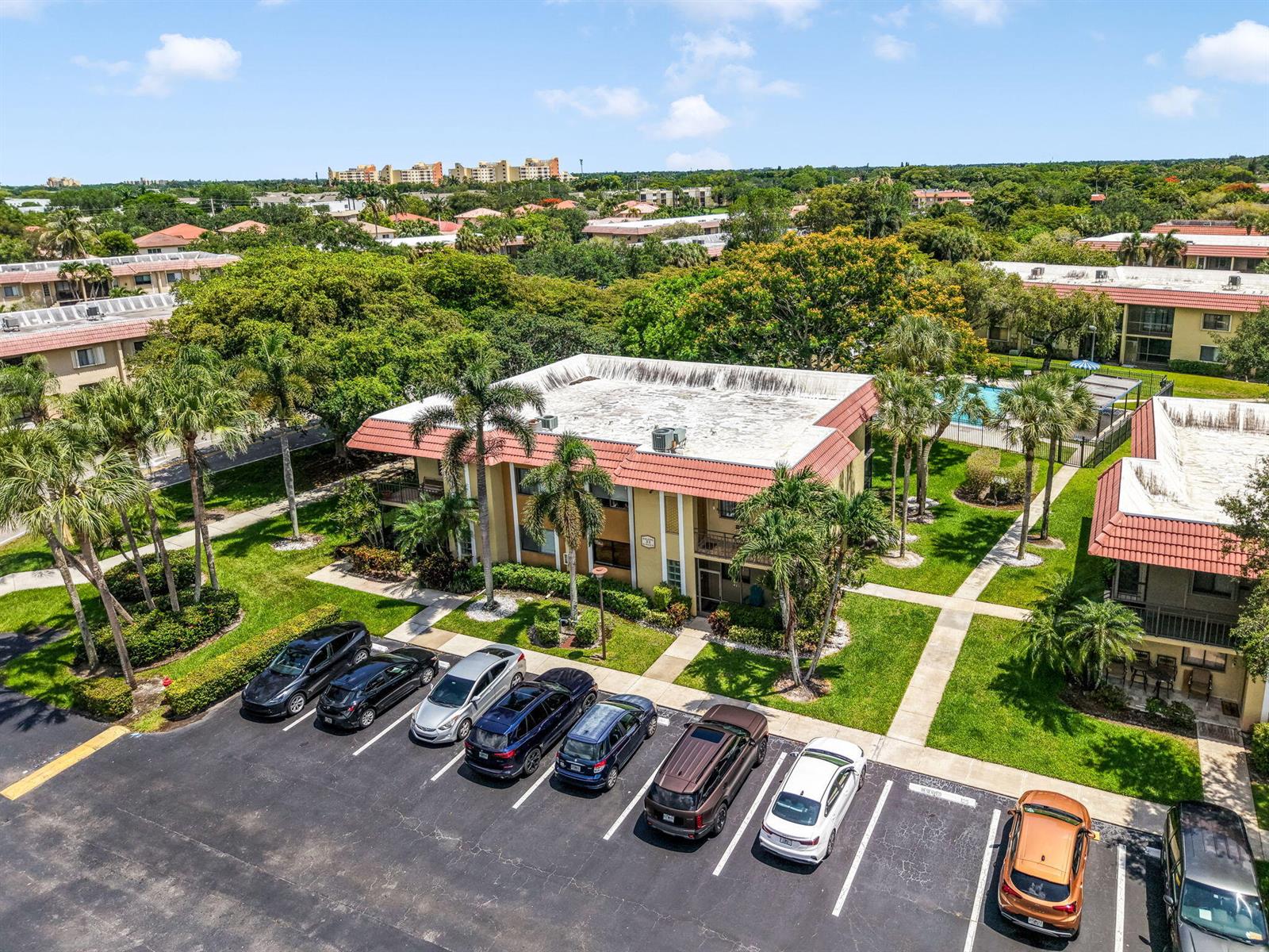 An aerial view shows a two-story apartment building with a tiled roof and parking lot — 303 Lakeview Drive # 102, Weston FL 33326, WESTON, FL