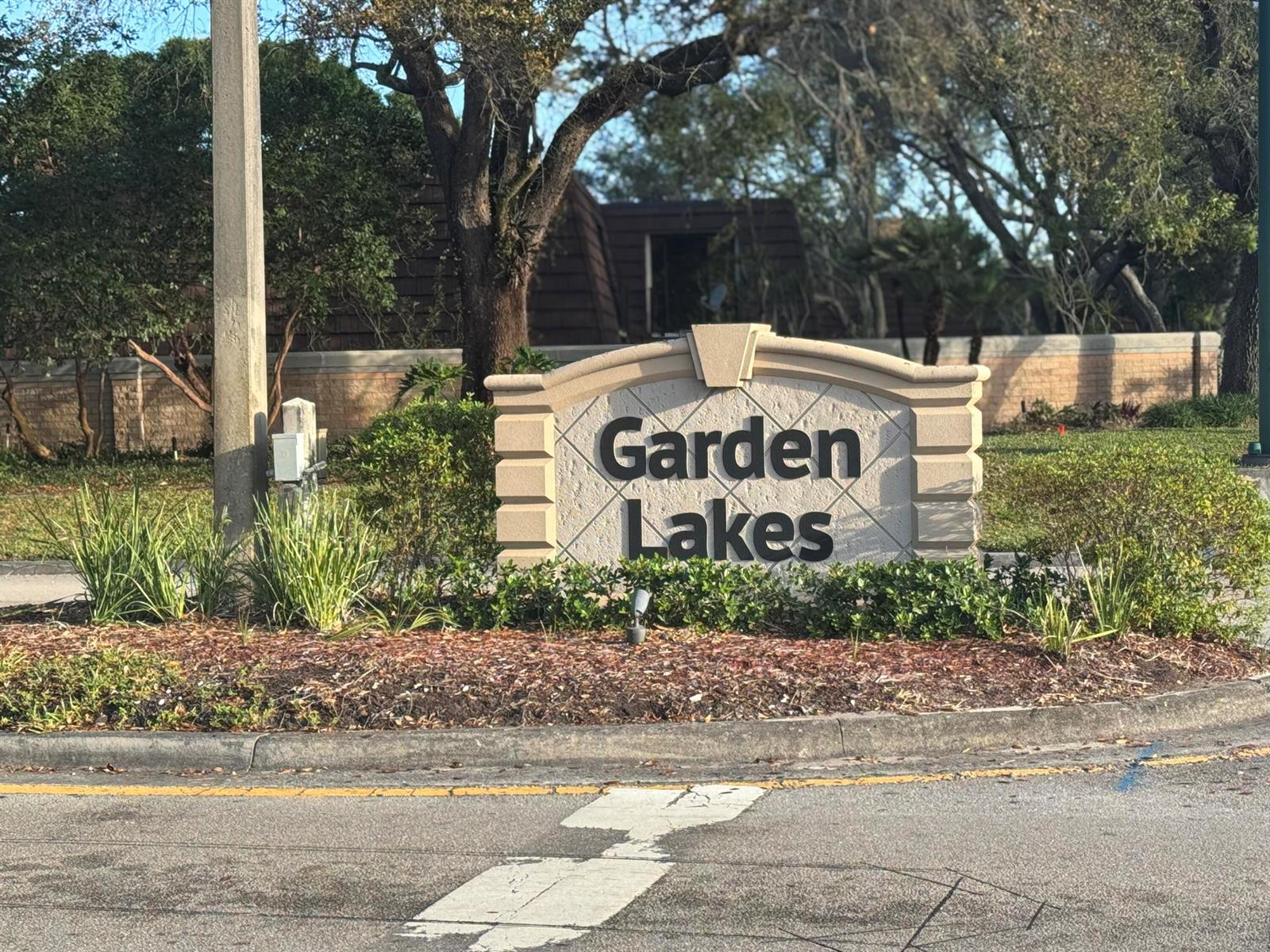 A stone monument sign for Garden Lakes stands in a landscaped area near a road — 219 2nd Lane, Palm Beach Gardens FL 33418, PALM BEACH GARDENS, FL