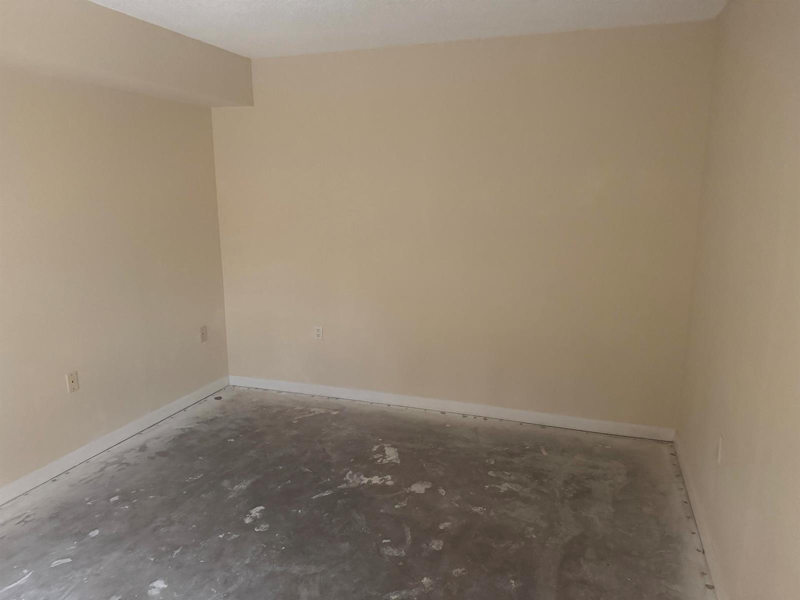 An empty room with beige walls, white baseboards, and a bare concrete subfloor — 219 2nd Lane, Palm Beach Gardens FL 33418, PALM BEACH GARDENS, FL