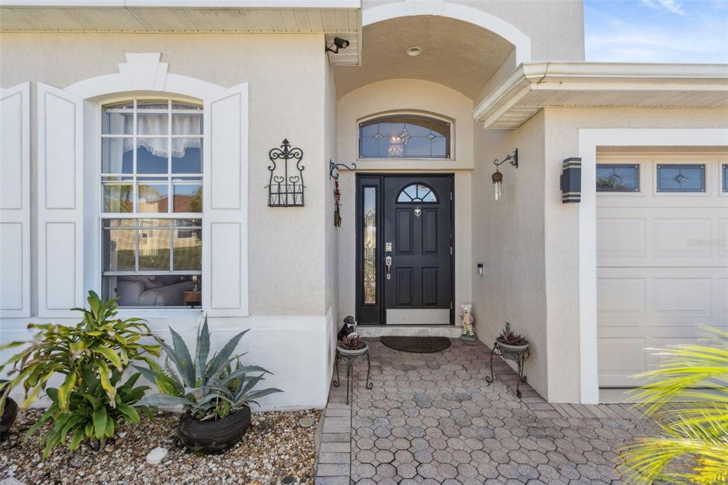 The exterior of a house features a black front door, arched entryway, and paved walkway — 722 BIRKDALE STREET, DAVENPORT, FL