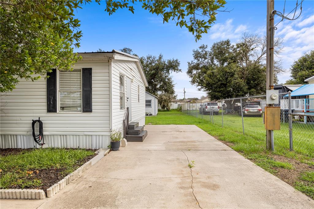 A white mobile home with a concrete driveway and a chain-link fence in the yard — 4332 UPPER MEADOW ROAD, MULBERRY, FL