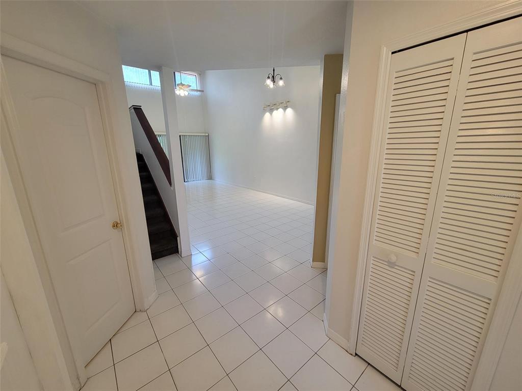 A tiled entryway leads to a living area with high ceilings and a staircase — 3333 GRAY FOX COVE UNIT 3333, APOPKA, FL