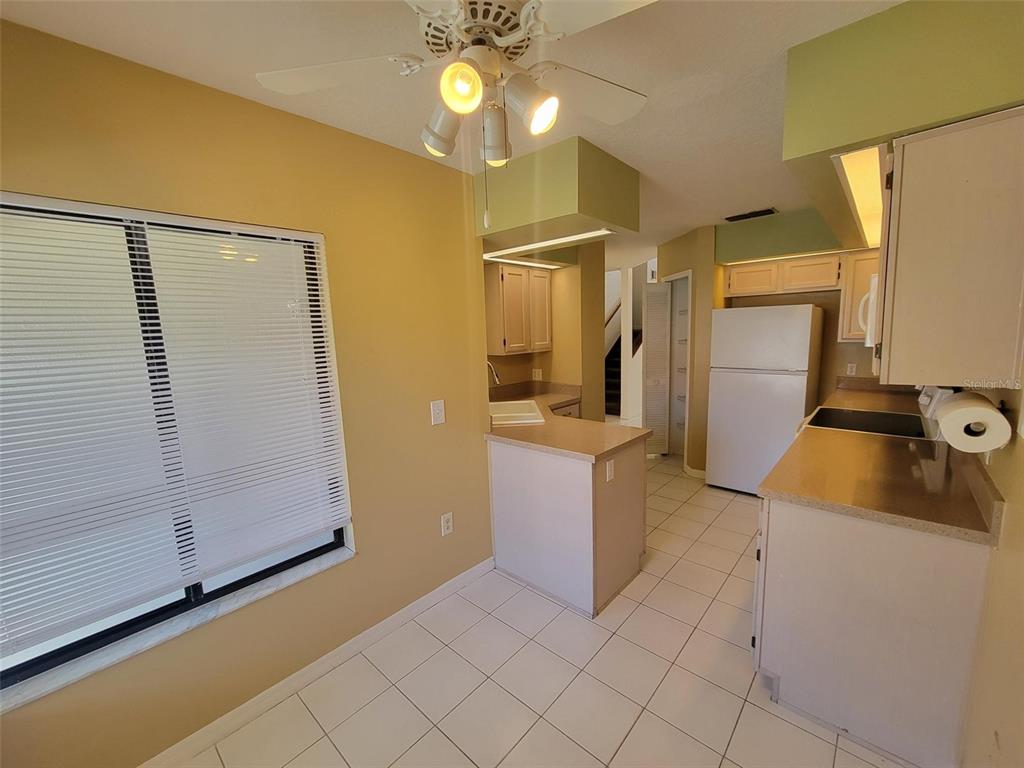 A kitchen with white tile floors, light-colored cabinets, and a ceiling fan — 3333 GRAY FOX COVE UNIT 3333, APOPKA, FL