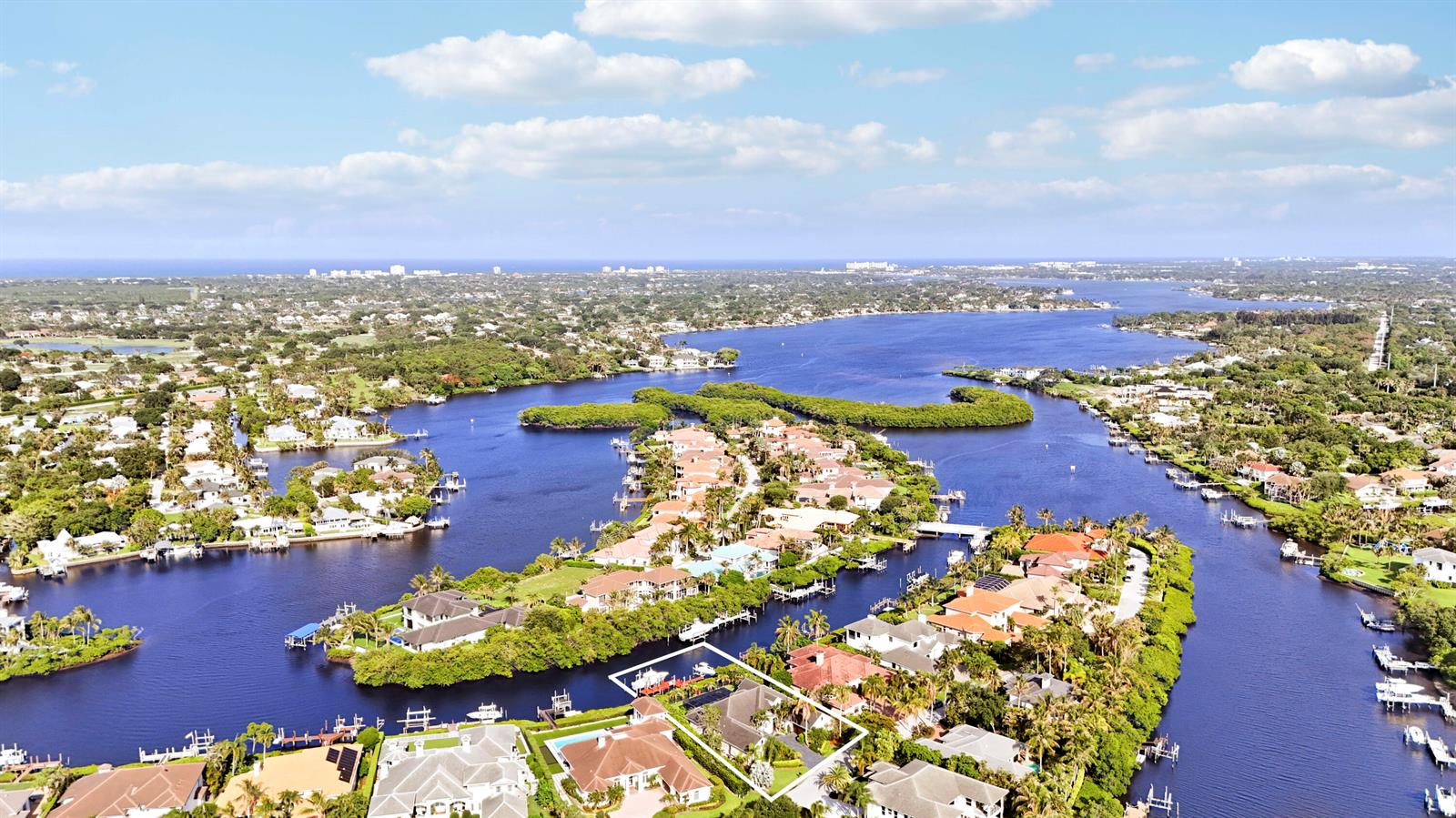 An aerial view shows a waterfront residential property with a boat dock and pool — 18989 SE Windward Island Lane, Jupiter FL 33458, JUPITER, FL