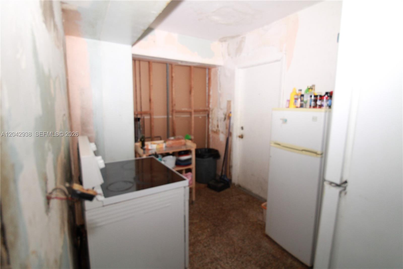 This kitchen is in a state of disrepair with exposed wall studs and unfinished surfaces — 10820 SW 220th St, Miami FL 33170, MIAMI, FL