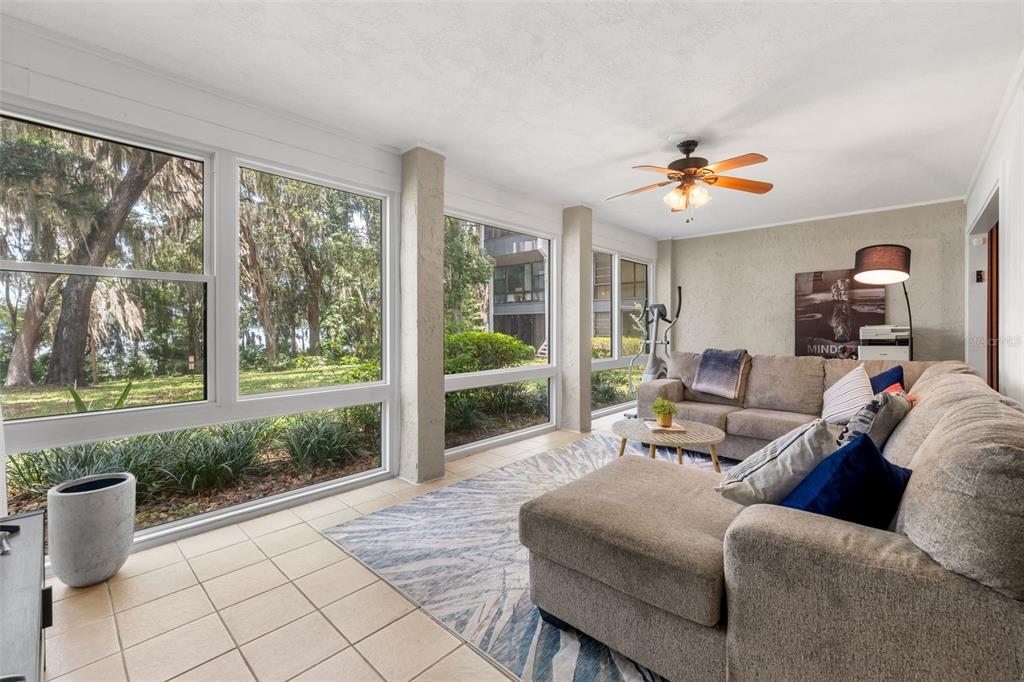 A sunroom with large windows, tile flooring, a sectional sofa, and a ceiling fan — 2660 SW 14TH DRIVE UNIT 125, GAINESVILLE, FL