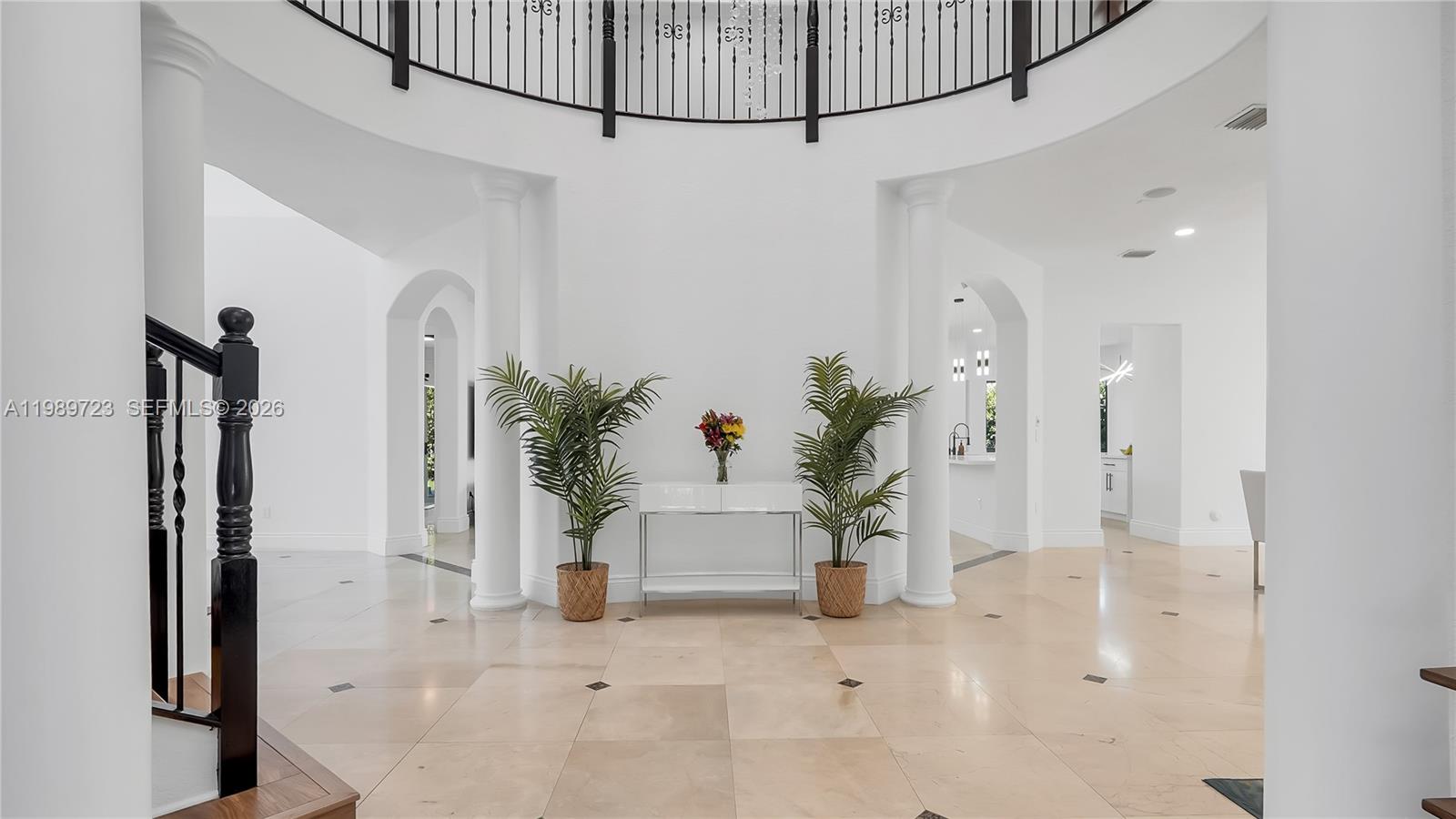 A bright, open foyer features a curved balcony, white columns, and light-colored tile flooring — 7965 SW 195th St, Cutler Bay FL 33157, CUTLER BAY, FL
