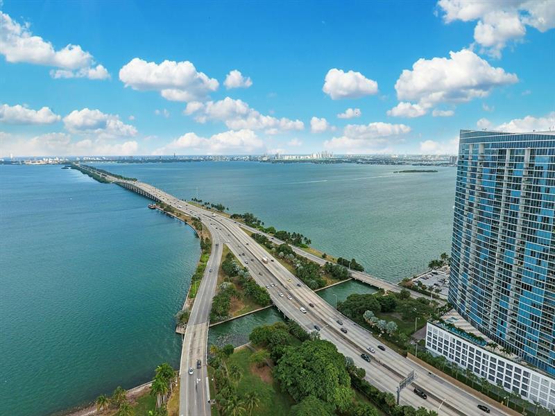 An aerial view shows a highway bridge crossing a bay next to a tall building — 601 NE 36th Street # 2806, Miami FL 33137, MIAMI, FL