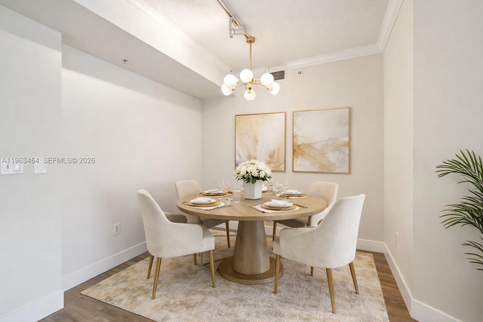 A dining room features a round wooden table, four upholstered chairs, and a modern chandelier — 2000 N Bayshore Dr # 304, Miami FL 33137, MIAMI, FL
