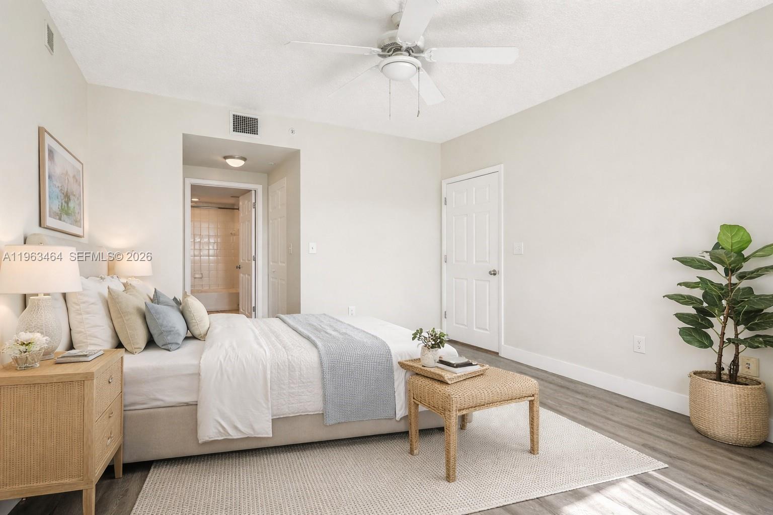A bedroom features a bed, a wicker bench, a potted plant, and an attached bathroom — 2000 N Bayshore Dr # 304, Miami FL 33137, MIAMI, FL