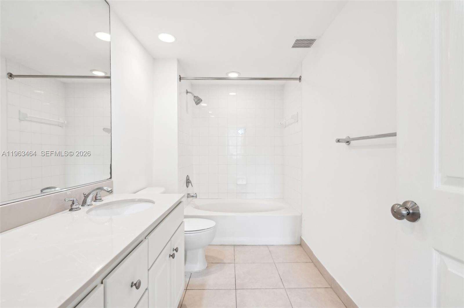 A white bathroom features a vanity, a toilet, and a shower-tub combination with tiled walls — 2000 N Bayshore Dr # 304, Miami FL 33137, MIAMI, FL