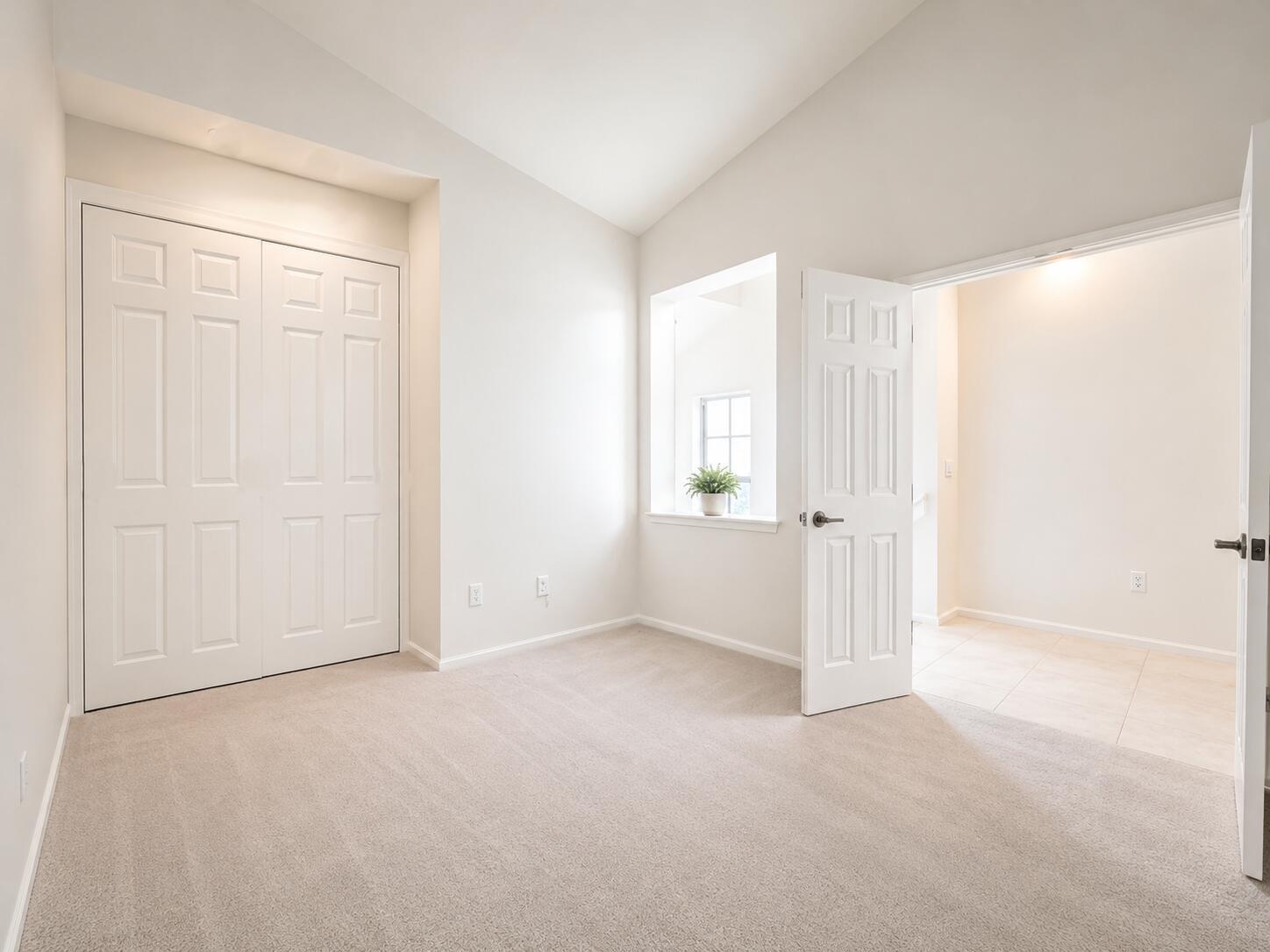An empty bedroom with beige carpet, white walls, a closet, and an open doorway — 6560 Villa Sonrisa Drive # 1321, Boca Raton FL 33433, BOCA RATON, FL