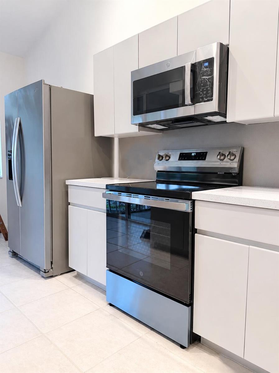 A kitchen features white cabinets, stainless steel appliances, and light-colored countertops — 6560 Villa Sonrisa Drive # 1321, Boca Raton FL 33433, BOCA RATON, FL