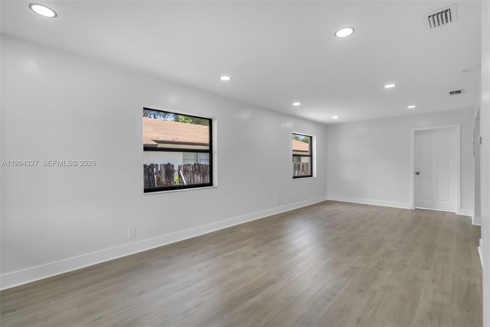 An empty room features white walls, recessed lighting, and light wood-look flooring — 914 S L St, Lake Worth FL 33460, LAKE WORTH, FL