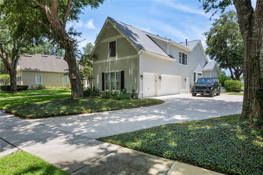 A bright entryway features light wood flooring, a central pendant light, and double wooden doors — 6241 BLAKEFORD DRIVE, WINDERMERE, FL