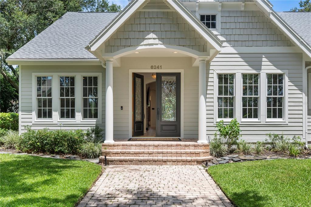 A dining room with a wooden table, clear chairs, and an arched entryway — 6241 BLAKEFORD DRIVE, WINDERMERE, FL