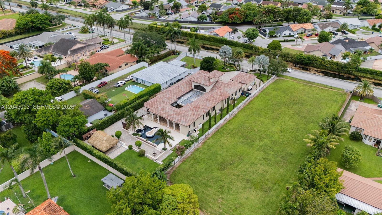 An aerial view shows a large house with a tiled roof, pool, and expansive lawn — 2835 SW 132nd Ave, Miami FL 33175, MIAMI, FL