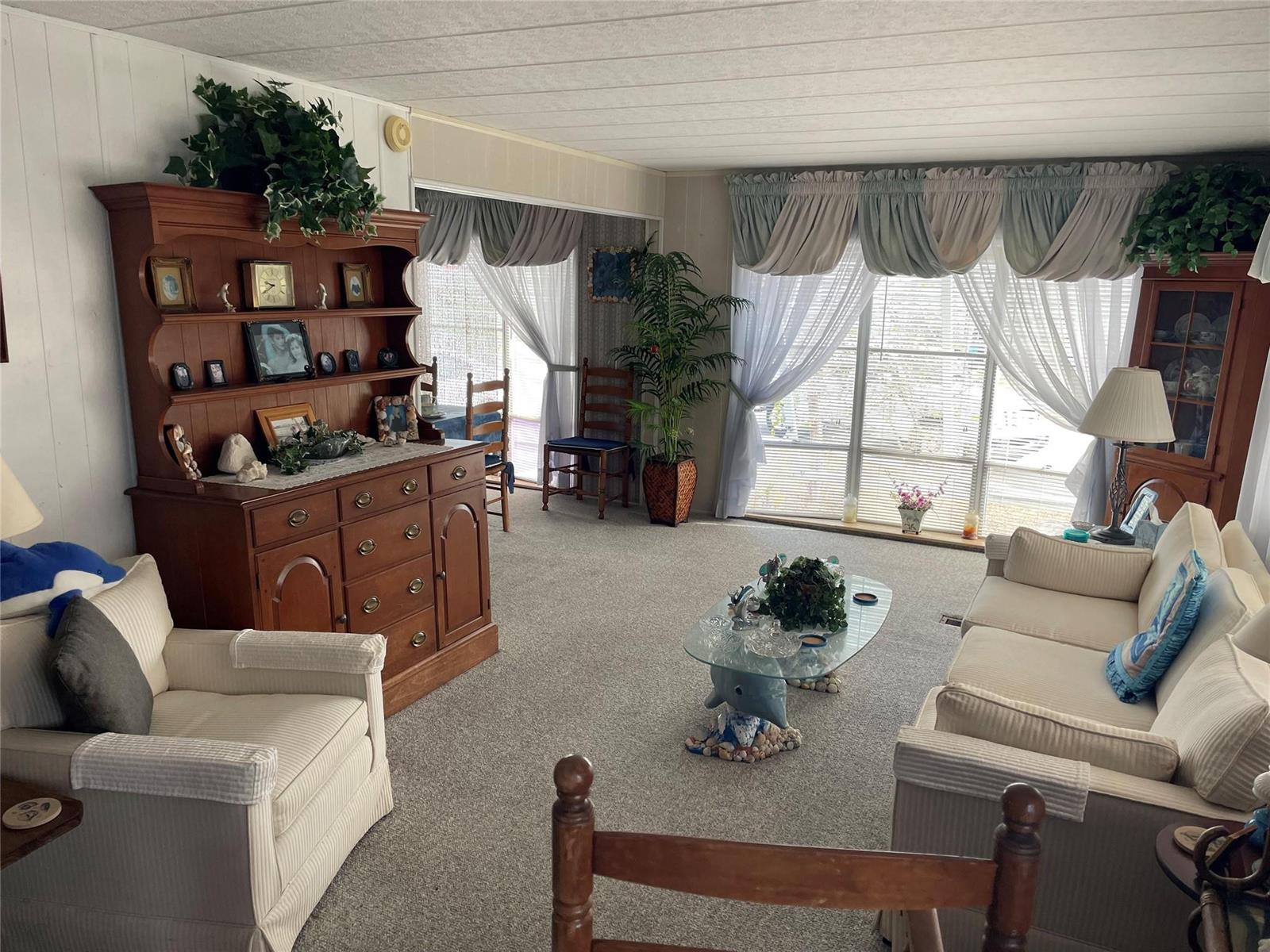 A living room features a wooden hutch, two beige sofas, and a glass coffee table — 8621 SW 18th Court, Davie FL 33324, DAVIE, FL