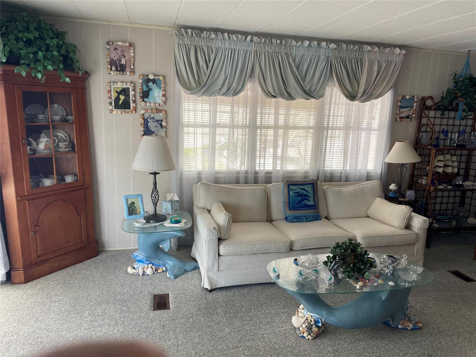 A living room features a striped sofa, two dolphin-themed glass tables, and a wooden cabinet — 8621 SW 18th Court, Davie FL 33324, DAVIE, FL