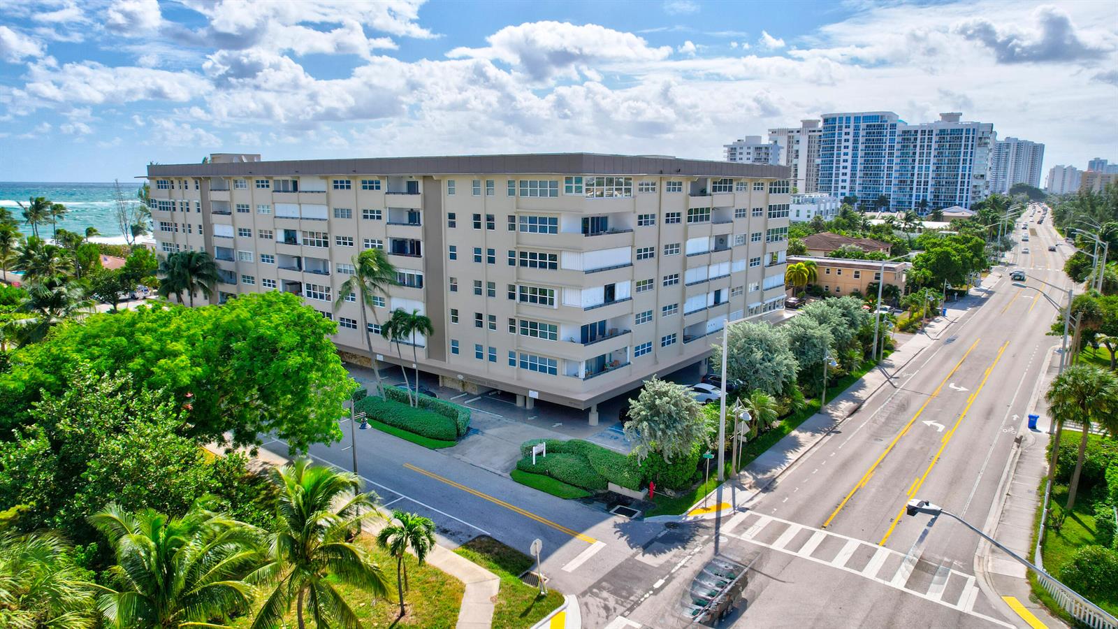 An aerial view shows a multi-story apartment building located near a beach and road — 401 Briny Avenue # 708, Pompano Beach FL 33062, POMPANO BEACH, FL